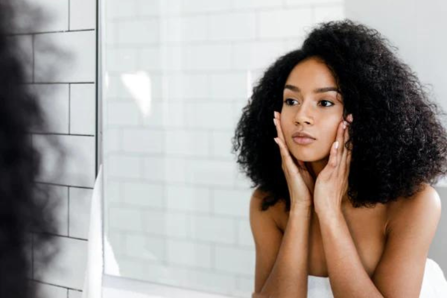 Woman with black hair look at herself in the mirror